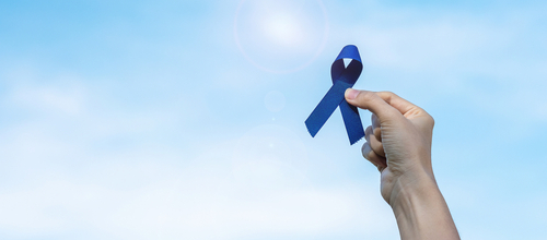 Une main qui tient un ruban bleu, symbole de la journée de sensibilisation à l'autisme
