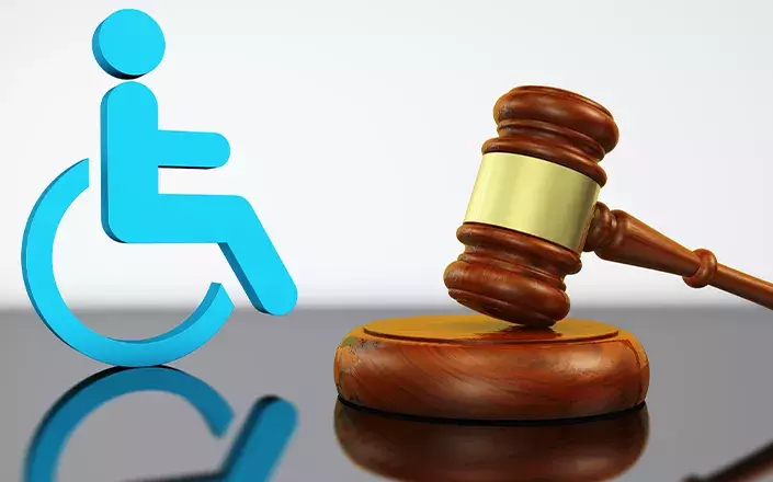 Icone d'une personne en fauteuil roulant à côté d'un marteau de la justice